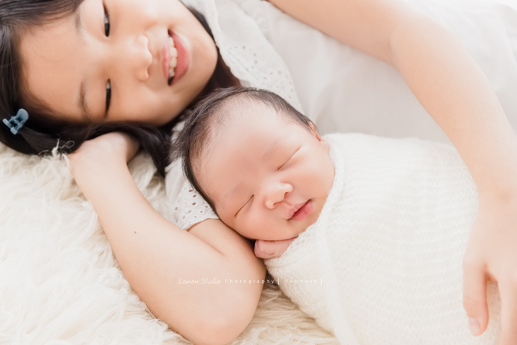 婕綝媽麻的三寶來拍新生兒寫真，這張是姊姊抱著三寶，三寶在睡夢中偷笑的相片！