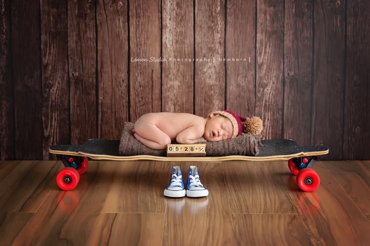 男寶寶乙緁出生13天大時的系列相片，這張相片很特別寶寶在爸拔的滑板上拍照，因為滑板是爸爸的興趣！