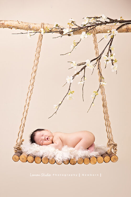 隨手分享新生兒寫真的相片，這張寶寶躺在木鞦韆上！