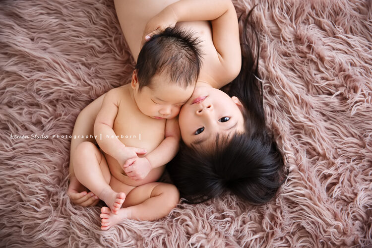 靜雯媽麻的二寶來拍新生兒寫真，專業的新生兒攝影留下這張寶寶跟姊姊美麗的合照