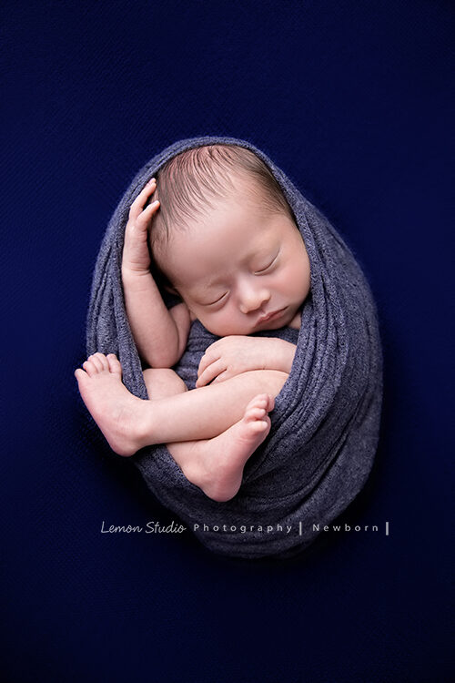 Eva媽麻的寶寶剛出生來檸檬巷館拍專業新生兒攝影，這張是紫色的布將寶寶包起來