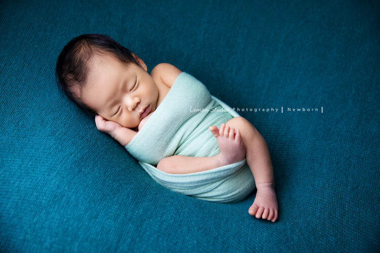 誼靜媽麻的寶寶來拍新生兒攝影，好可愛的寶寶，寶寶跟這張相片裡的藍色的背景好搭，會是很棒的彌月相片
