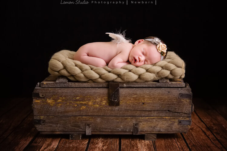 剛出生不久的小昀軒來工作室拍新生兒寫真，這張昀軒趴睡在木箱及毯子上，相片透露出寧靜祥和的氛圍
