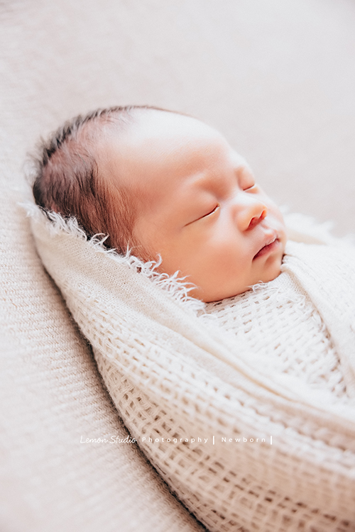 Ida媽麻的二寶男寶寶的新生兒寫真照，繼上次姊姊寶寶時來拍照後，弟弟來報到了！黎爸拍的新生兒寶寶照，每張都像藝術品啊！這張寶寶睡著的樣子包在布裡好美啊！