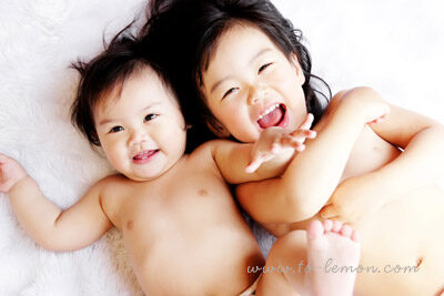 可愛的凱希和漂亮的姊姊子芸一起來拍照，這張是姐妹倆躺在白色的毛毯上的合照！