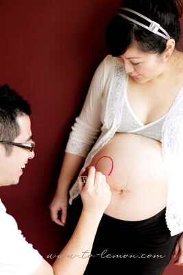 盈盈媽麻懷了龍鳳胎和先生一起來拍照，這張是爸拔正在盈盈媽麻肚子上畫畫