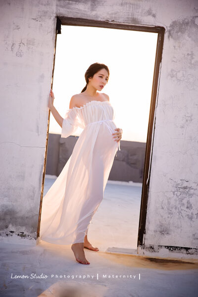 這張是隨手分享的孕媽媽寫真照，相片裡的孕媽媽穿著一襲白色禮服，在夕陽的光下好美啊！