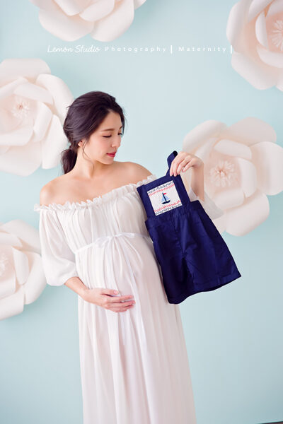這張是隨手分享的孕媽媽寫真照，相片裡的孕媽媽拿著她為寶寶準備的衣服！
