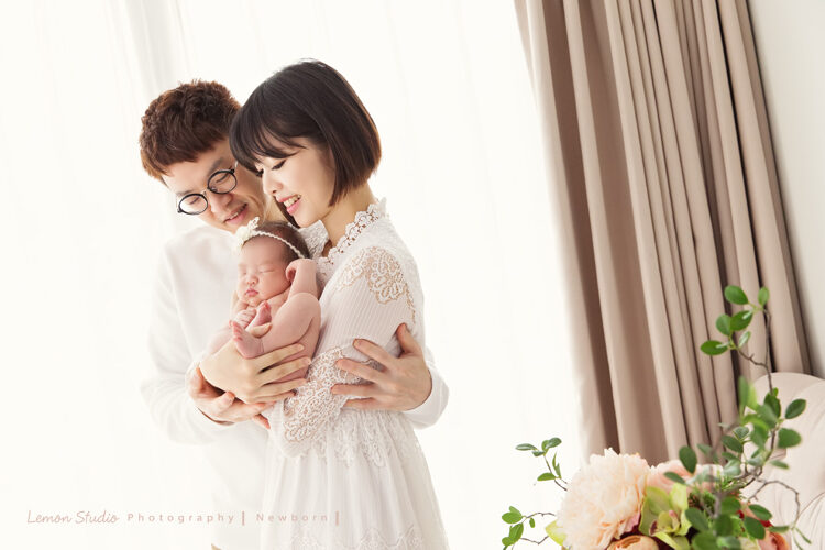 倩兒媽麻一家來拍新生兒寶寶攝影，這張爸拔媽麻抱著寶寶站在窗邊！