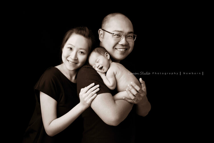 珮綺媽麻一家來拍新生兒寶寶紀錄，這張寶寶在爸拔媽麻身上睡著且在睡夢中笑得很燦爛，太經典的黑白全家福了