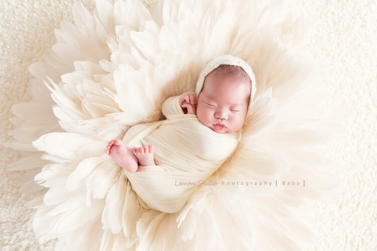 台南小小John一家的新生兒寫真系列相片，這張白布包起來的John躺在白色的花及布上好美啊！