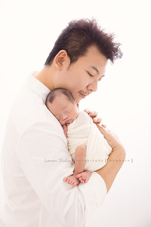 彥君媽麻一家來拍新生兒攝影，這張爸爸抱著熟睡的寶寶