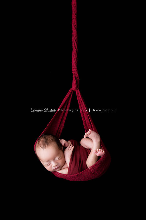彥君媽麻一家來拍新生兒攝影，這張寶寶包吊掛在紅色的布裡好美啊！