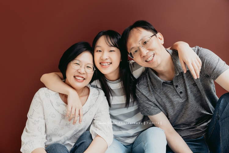 Coco媽麻一家來拍週年紀念照，這張一家三口在磚紅色的背景前拍攝的全家福！