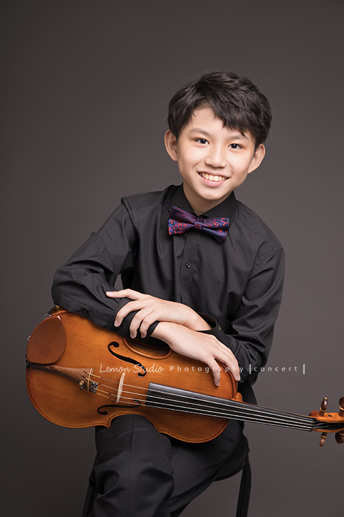 Arthur是學校弦樂團的一員，這天和團員們為了即將來到的音樂會一起來拍照！這是Arthur為了音樂會第二次來拍照，Arthur這次來感覺也長大了許多啊！這張是Arthur與提琴的合照！Arthur的笑容既有自信又迷人！