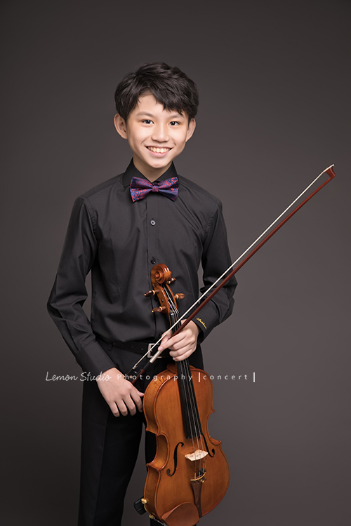 Arthur是學校弦樂團的一員，這天和團員們為了即將來到的音樂會一起來拍照！這是Arthur為了音樂會第二次來拍照，Arthur這次來感覺也長大了許多啊！這張是Arthur與提琴的合照！Arthur的笑容好迷人！