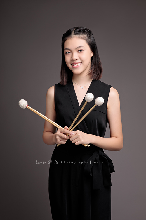 珈瑄學的樂器是馬林巴木琴，這天帶著琴棒來拍照！這張是珈瑄手拿琴棒的相片！珈瑄有迷人的氣質！