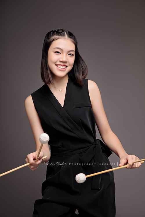 珈瑄學的樂器是馬林巴木琴，這天帶著琴棒來拍照！這張是珈瑄手拿琴棒感覺正在彈琴的樣子，可以感受到珈瑄喜愛音樂享受音樂的氛圍！