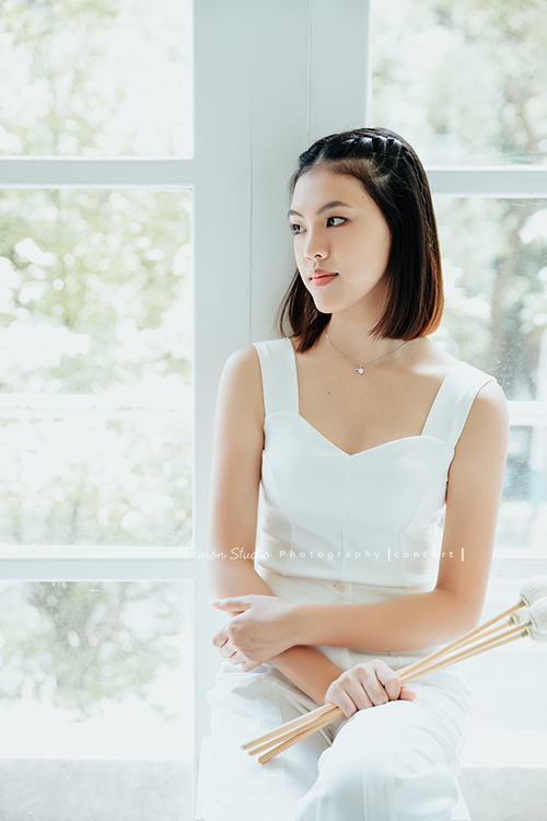 珈瑄學的樂器是馬林巴木琴，這天帶著琴棒來拍照！這張是珈瑄換上白色的服裝手拿琴棒的相片！