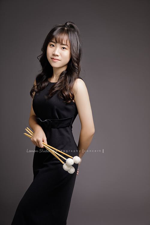 就讀高中的亞璇，學習的樂器是馬林巴木琴，和之前來拍照的珈瑄是好朋友！這天亞璇穿著黑色洋裝入鏡，拍起來非常有氣質很美啊！這張亞璇一手拿琴棒，一手放後面，帶著微笑看鏡頭，很有氣質且親切的一張相片