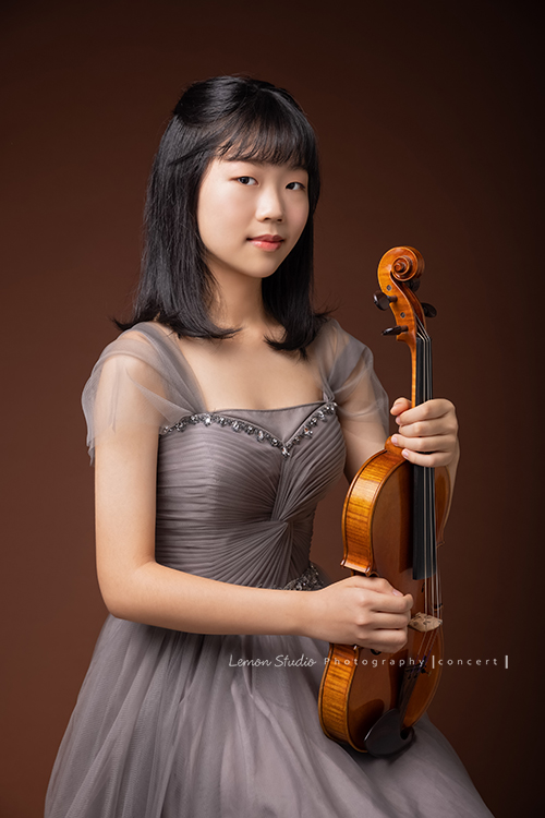 映萱是學校國中弦樂團的首席!很沈穩及自信的映萱為了即將來到的音樂會拍照,這張是映萱手拿著提琴坐著拍照的樣子,映萱落落大方,很有氣質!