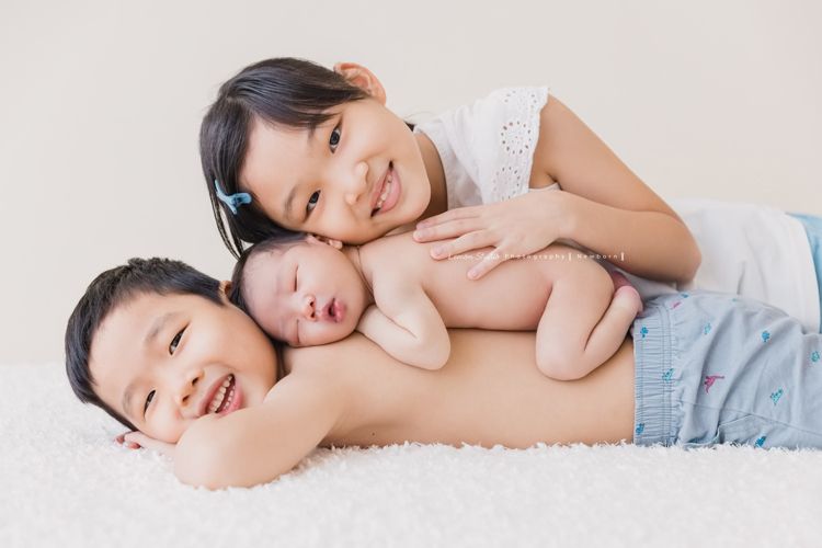 婕綝媽麻的三寶來拍新生兒寫真，這張是三寶趴在開心的哥哥姊姊中間的相片！