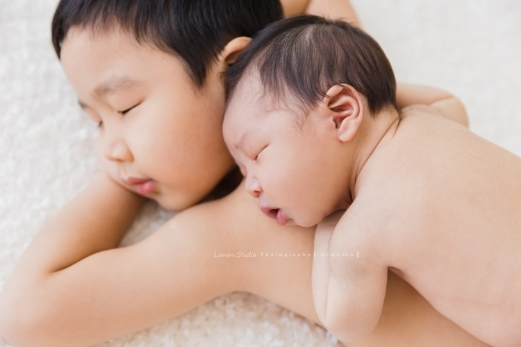 婕綝媽麻的三寶來拍新生兒寫真，這張是三寶趴在哥哥身上的相片！