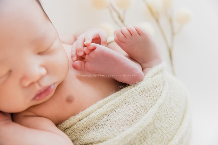 婕綝媽麻的三寶來拍新生兒寫真，這張是三寶包在綠色的布裡腳丫丫露出來的相片！