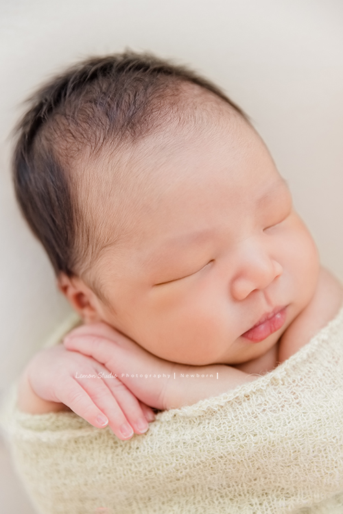 婕綝媽麻的三寶來拍新生兒寫真，這張是三寶包在綠色的布裡的大頭照相片！