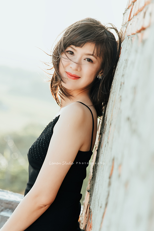 單身時的Tina來拍個人寫真，女人到了一個年紀，散發出來的美很不一樣，Tina舉手投足之間，有優雅、有智慧、自然，不需要刻意的表現，但卻有發自內心的美！這張的Tina穿黑色洋裝背靠著牆，很美很自然地看著鏡頭！微風吹著他的頭髮好美！