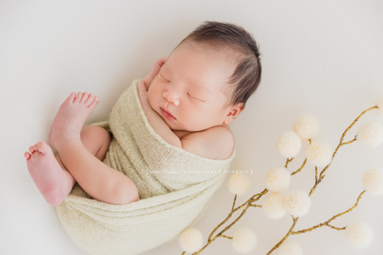 婕綝媽麻的三寶來拍新生兒寫真，這張是三寶包在綠色的布裡乖乖睡的相片！