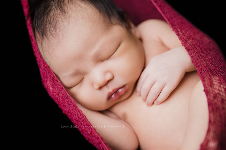 婕綝媽麻的三寶來拍新生兒寫真，這張是三寶掛在紅色的布裡乖乖睡的相片！