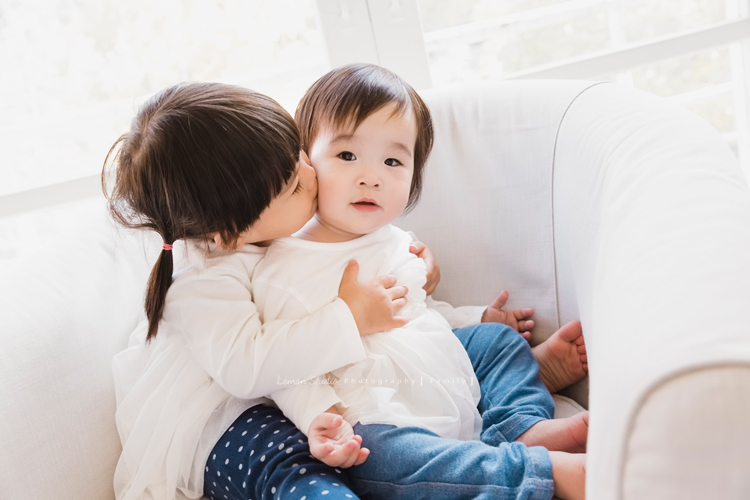 上次來拍照時大寶七個半月大，一年半不見，這次來拍寶寶攝影已經是三姊妹了！這次是姊姊三歲＆妹妹們11個月大的紀念！這是小姊姊親親妹妹的相片！小姊姊感覺好溫柔好照顧妹妹啊！