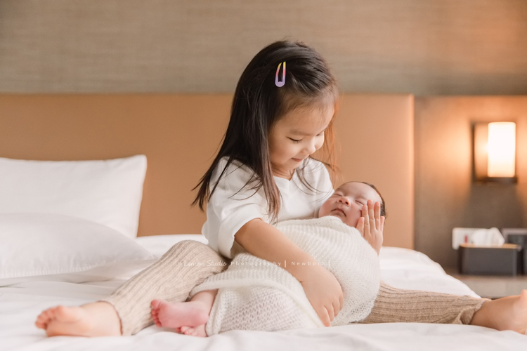 三歲的沐芯當姊姊了好開心啊，這次是拍弟弟的新生兒攝影，承錇媽麻在生產前與黎爸溝通，不用新生兒的可愛道具，希望自然感覺的拍攝，這張是小姊姊抱著充滿愛地看著睡著的弟弟的相片！