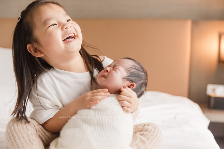 三歲的沐芯當姊姊了好開心啊，這次是拍弟弟的新生兒攝影，承錇媽麻在生產前與黎爸溝通，不用新生兒的可愛道具，希望自然感覺的拍攝，這張姊姊抱著快哭的弟弟！