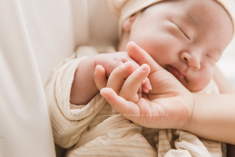 三歲的沐芯當姊姊了好開心啊，這次是拍弟弟的新生兒攝影，承錇媽麻在生產前與黎爸溝通，不用新生兒的可愛道具，希望自然感覺的拍攝，這張是小姊姊的手牽著弟弟的小手的合照！