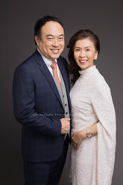 綠佳利公司的一個團隊一起來拍形象照，這對夫妻檔穿著正式的服裝一起拍照！太太穿上白色有華貴感的洋裝，先生穿上西裝，很美的一張相片！