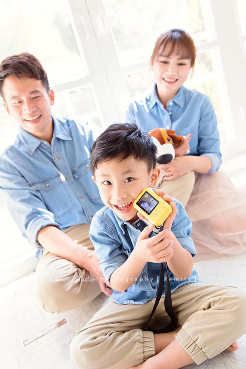 剛滿五歲的杰睿跟爸拔媽麻來拍家庭寫真,這張是杰睿坐在爸拔媽麻前面在玩著他的小相機的相片!