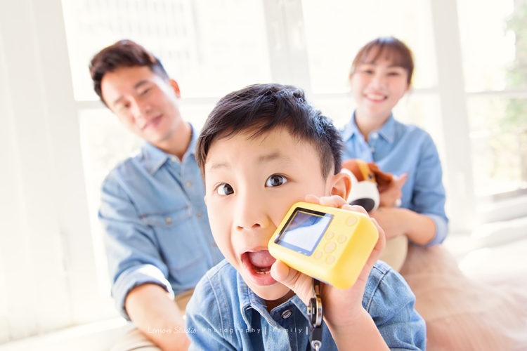 剛滿五歲的杰睿跟爸拔媽麻來拍家庭寫真,這張是杰睿坐在爸拔媽麻前面在玩著他的小相機、帶著逗趣的表情的可愛相片!