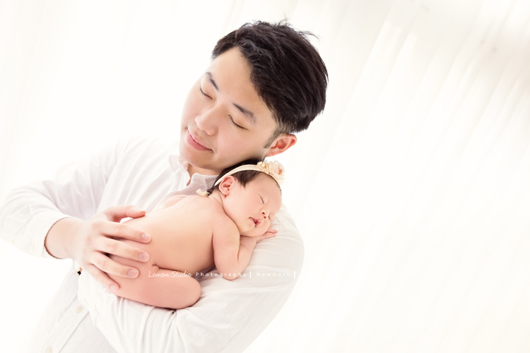 嘉葆媽麻一家人在寶寶 26天大時來工作室拍新生兒寫真，這張是爸拔抱著熟睡的寶寶！