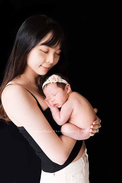 嘉葆媽麻一家人在寶寶 26天大時來工作室拍新生兒寫真，這張是媽麻抱著寶寶的另一系列的合照！