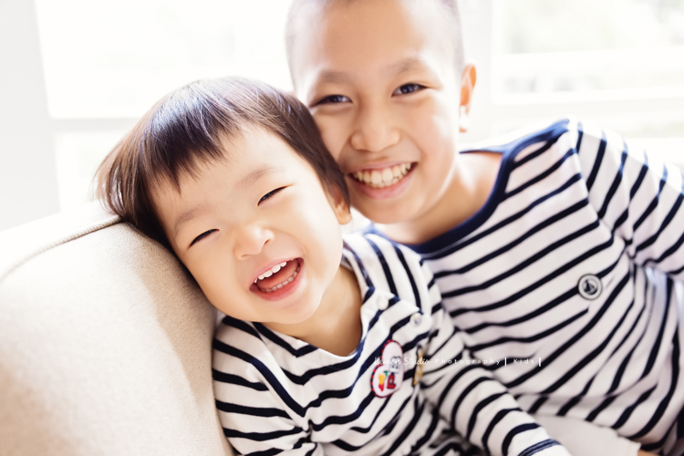 可愛的一佳即將滿周歲時來拍寶寶寫真，這次的一佳好多表情，跟哥哥及媽麻好多互動！這張是可愛的一佳在哥哥身旁笑得很燦爛的模樣！好美的笑容啊！