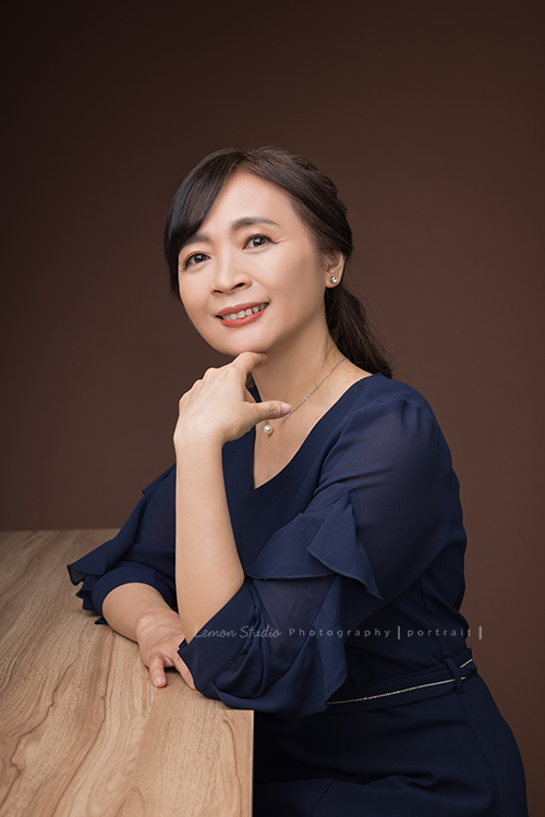大大顧問瑞琳來拍專業形象照,這張是瑞琳在深咖啡紅背景前,坐在桌前笑得很美很優雅的一張形象照!