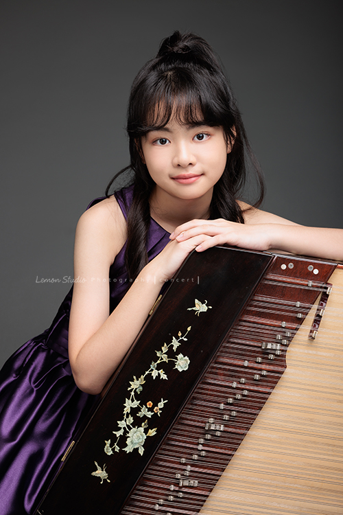 彈奏國樂的揚琴的子晴，這天身穿一襲紫色禮服，將她的揚琴帶到現場拍攝音樂會的相片！這張是子晴靠在揚琴上對著鏡頭微笑的相片！